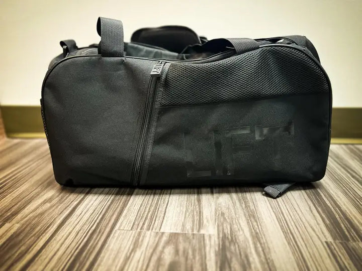 Black duffel bag or gym bag with straps.