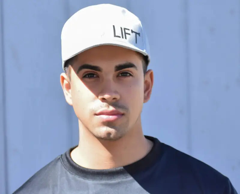 Man wearing a white cap with ’LIFT’ printed on it.