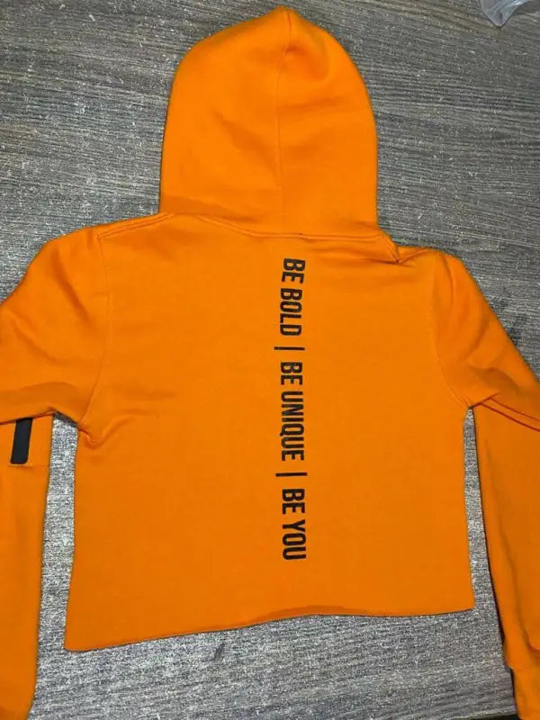 Bright orange cropped hoodie with black text down the back.