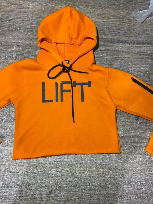 Bright orange cropped hoodie with ’LIFT’ printed on the front.