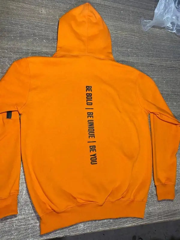 Bright orange hooded sweatshirt with black text on the back.