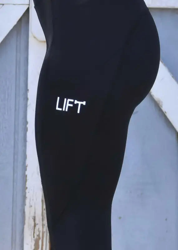 Black leggings or tights with ’LIFT’ printed on the side.