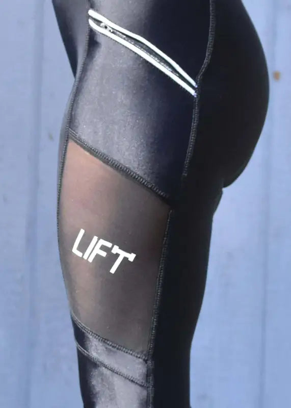 Athletic leggings with ’LIFT’ printed on the thigh area.
