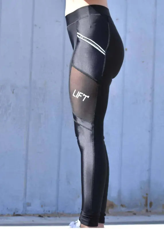 Black athletic leggings with ’UFT’ branding and mesh panels.
