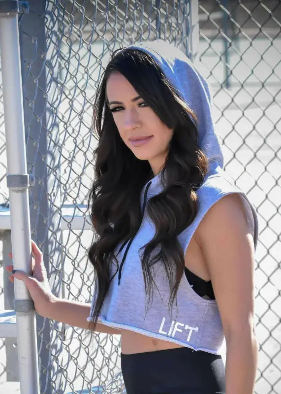 Woman with long dark hair wearing a light blue crop top.