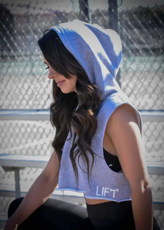 Woman wearing a blue and white hooded athletic top with ’LIFT’ printed on it.