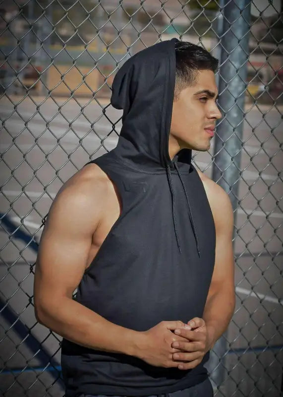 Muscular young man wearing a sleeveless gray hoodie.