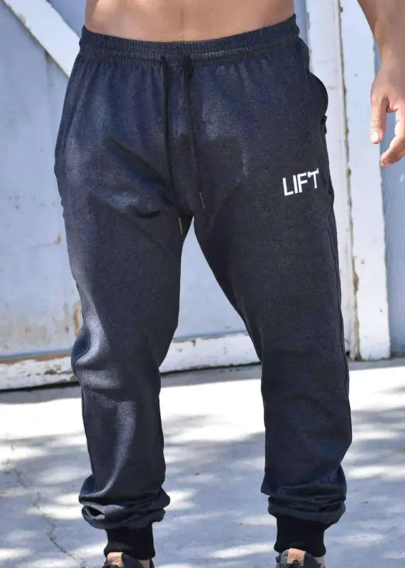 Dark blue sweatpants with ’LIFT’ printed on the thigh.