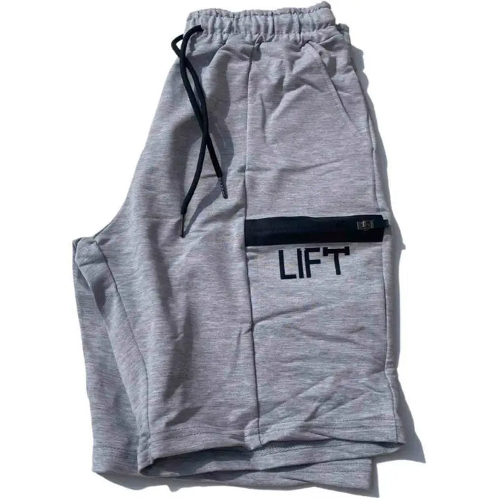 Gray sweatpants with ’LIFT’ printed on a side pocket.