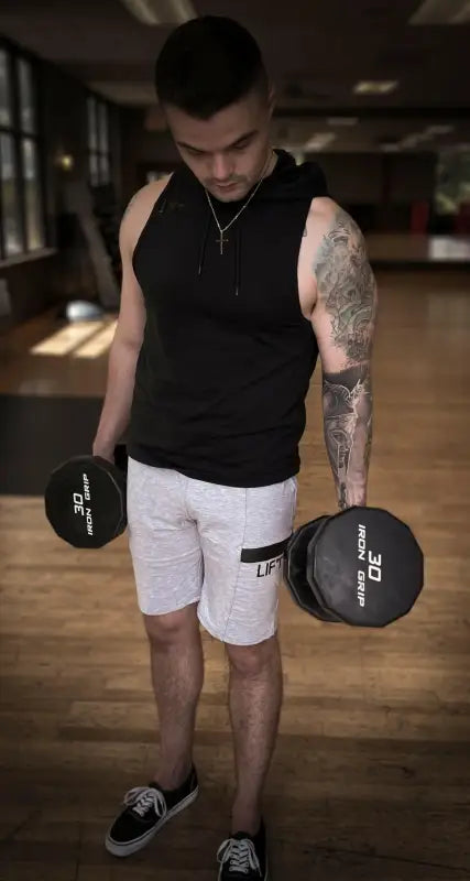 Man lifting dumbbells in a gym setting.